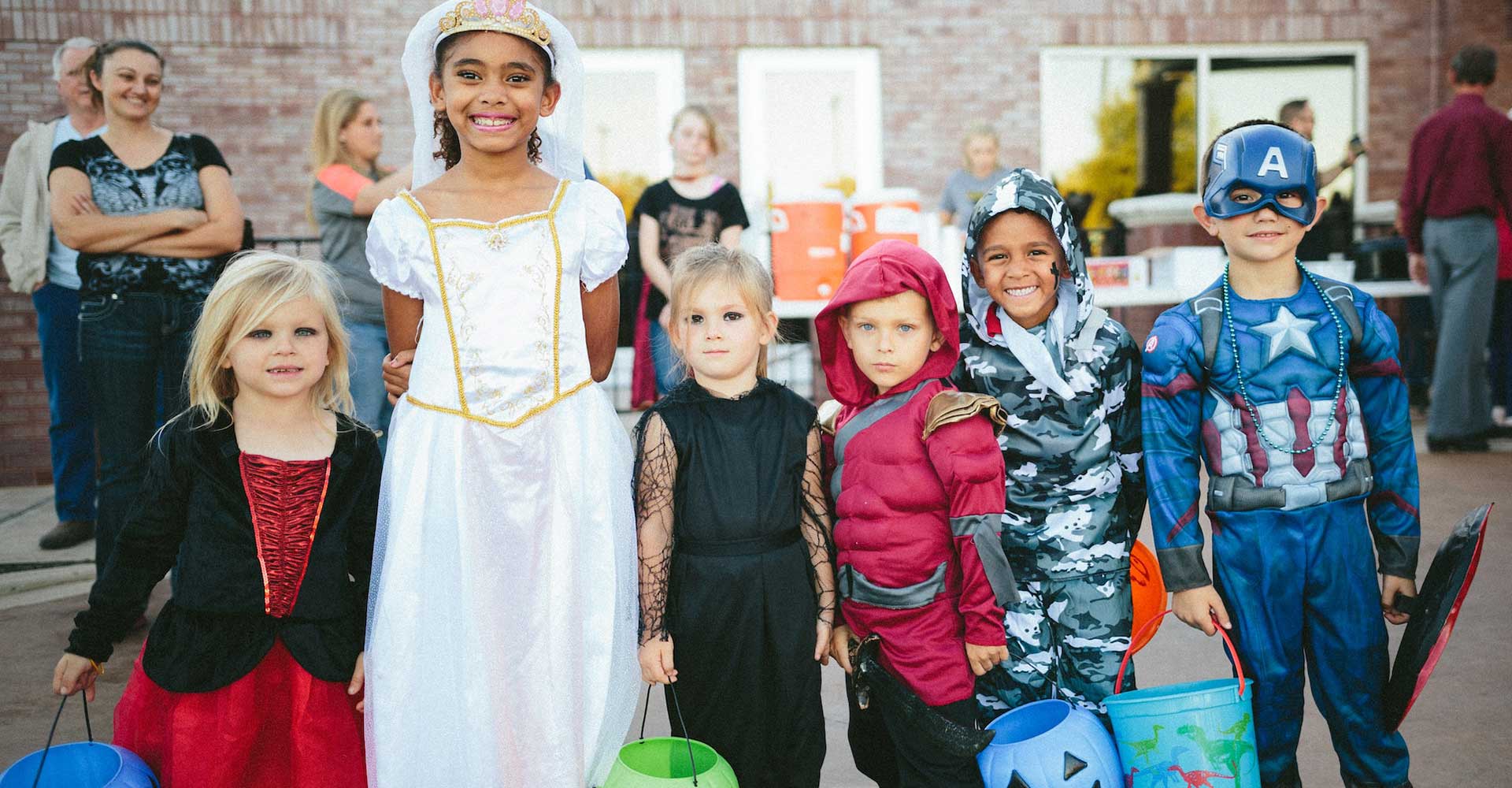 group-of-children-in-costumes-standing-strong-smiling-for-camera